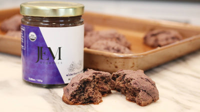 Elderberry Almond Butter jar next to a broken in half blueberry elderberry cookie
