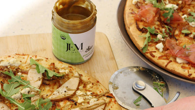 Two flatbread pizzas with vegetables and cured meats.