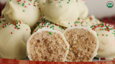 Almond butter filled snowballs covered in white chocolate and rainbow sprinkles