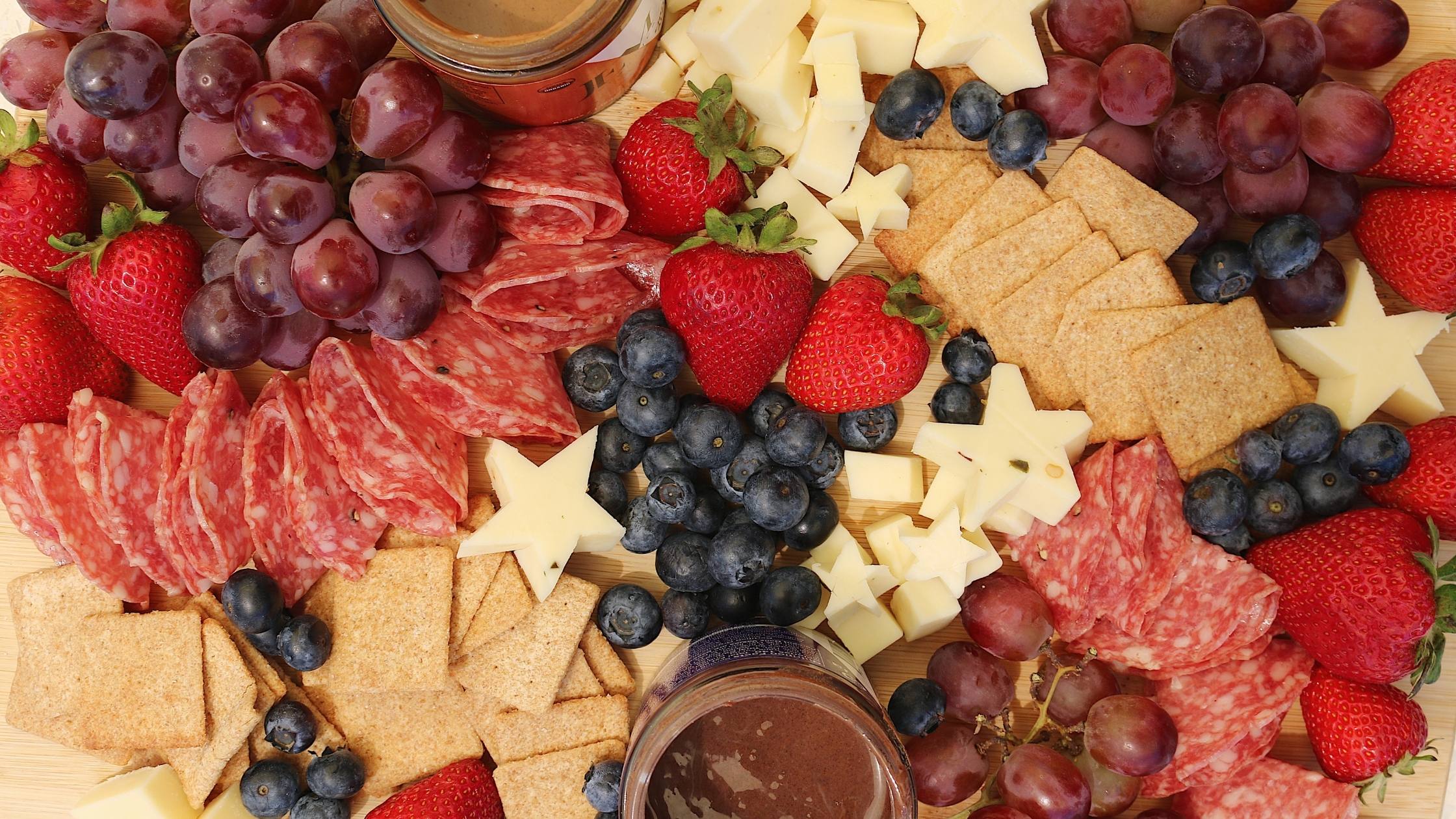 Assorted meat, fruit and cheese on a board