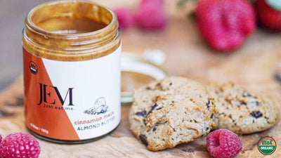JEM Organics Cinnamon Maca Almond Butter 6 oz jar next to cookies and raspberries