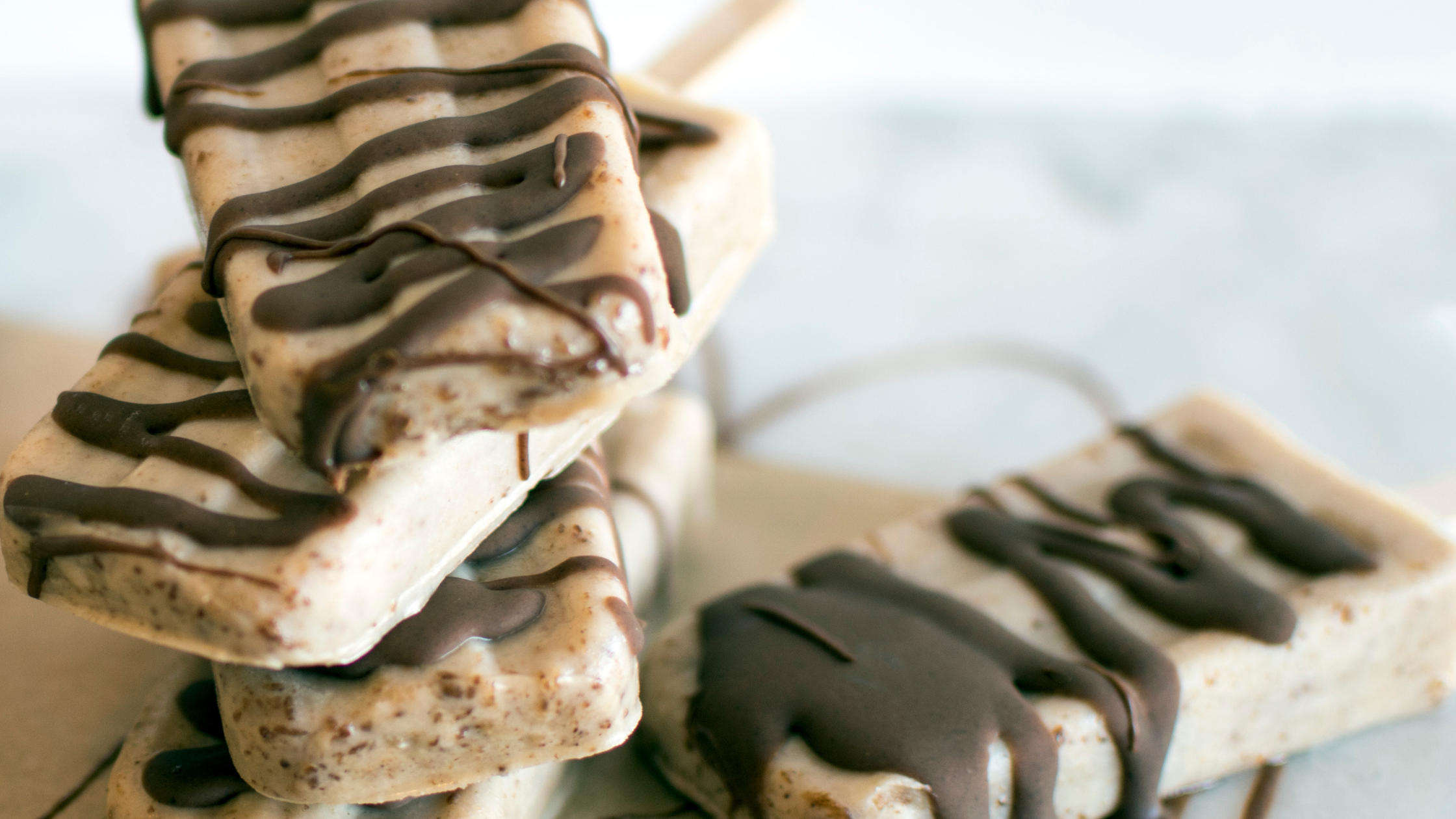 Homemade ice cream pops with nut butter drizzle.